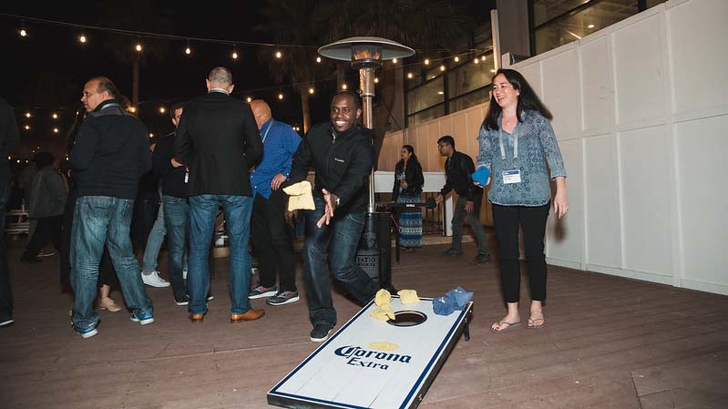 ServiceMax employees playing a game of Cornhole at an outdoor dinner party